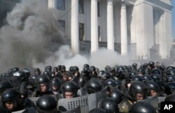 Smoke rises outside Ukraine's parliament building as riot police clash with nationalist protesters, in Kyiv, Aug. 31, 2015.