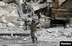 A Turkish-backed Free Syrian Army fighter gestures after Free Syrian Army forces took control of Kafr Jana village, north of Afrin, Syria, March 7, 2018.