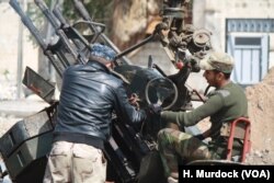 Soldiers prepare weapons to fire at IS as helicopters shoot at militants from above, in Mosul, March 29, 2017.
