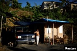 Jorge Salgado poses for a picture next to a house he built with parts of his house, which was destroyed by Hurricane Maria, Dec. 12, 2017. Salgado said: "I lost everything, but we have to keep living."