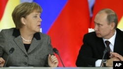 Russian President Vladimir Putin, right, and German Chancellor Angela Merkel speaks to each other after a signing ceremony during a Russian-German business forum in the Grand Kremlin Palace in Moscow, Friday, Nov. 16, 2012.