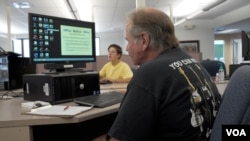 Custodial worker Glenn Hendrickson studies job openings at CareerLink, the PA employment office. He is not interested in farm work. (M. Kornely/VOA)
