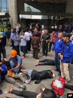 An Indonesian worker attends one of evacuated victims after a structure inside the Jakarta Stock Exchange tower collapsed in Jakarta, Indonesia, Monday, Jan. 15, 2018.