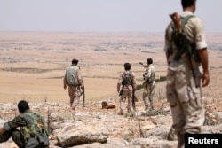 FILE - Fighters of the Manbij military council, take an overwatch position in the southern rural area of Manbij, Syria June 1, 2016.