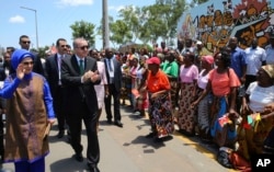 Turkey's President Recep Tayyip Erdogan and his wife, Emine Erdogan, greet local people during a ceremony in Maputo, Mozambique, Jan. 24, 2017. Erdogan has arrived in Mozambique on an Africa tour in which he is promoting trade and asking governments to crack down on schools and other institutions linked to Fethullah Gulen, a Muslim cleric accused of organizing a coup attempt in Turkey last year.