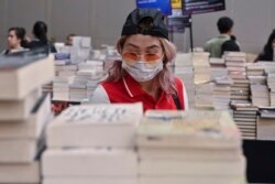 Ilustrasi. Seorang pengunjung pameran buku di Jakarta mengenakan masker untuk melindungi dari penularan virus corona, 8 Maret 2020. (Foto: AFP)