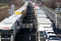 Trucks stand on the highway close to the border between Austria and Hungary near Bruck an der Leitha, Austria, Wednesday, March 18, 2020. Hungary has closed the border due to the new coronavirus outbreak. (AP Photo/Ronald Zak)