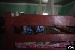 A former Al Shabab member texts on his phone while lying on his bed in a dormitory at a rehabilitation center for former militants in Baidoa, Somalia, Sept. 17, 2016. (Photo: J. Patinkin/VOA)
