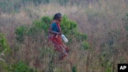 Seorang perempuan India berjalan di sebuah tanah lapang setelah buang air buka di lapangan terbuka pada Hari Toilet Sedunia di pinggiran Jammu, India, 19 November 2014.