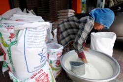 រូបឯកសារ៖ អាជីករម្នាក់កំពុងរើសសំបកស្រូវតូចៗចេញពីអង្ករ នៅតូបលក់អង្ករមួយកន្លែងនៅរាជធានីភ្នំពេញ ថ្ងៃទី១៧ ខែមេសា ឆ្នាំ២០១៩។