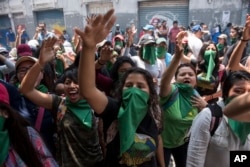 Youths shout slogans against the government of President Jimmy Morales, in Guatemala City, Sept. 11, 2018.
