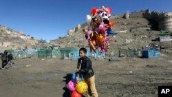 Seorang anak berjualan balon di Kabul, 23 Maret 2017.