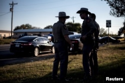 Members of the Wilson County Sheriff's office stand inside a taped off area near the First Baptist Church in Sutherland Springs, Texas, Nov. 5, 2017.
