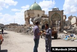 Many areas once controlled by Islamic State militants are still destroyed more than nine months after the battle. Behind these men is the ruins of the al-Nouri Mosque in Mosul, Iraq, May 9, 2018.