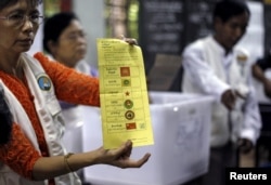 FILE - Volunteers count votes at a polling station during Myanmar general elections in central Yangon, Nov. 8, 2015.