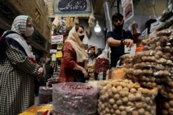 Women wearing protective face masks shop at a bazaar following the outbreak of the coronavirus disease (COVID-19), in Tehran, Iran, July 8, 2020.