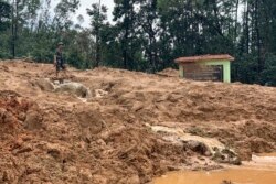Seorang perwira militer berdiri di lokasi longsor di pos penjaga hutan, provinsi Thua Thien-Hue, Vietnam, Kamis, 15 Oktober 2020.