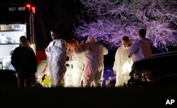Members of law enforcement stage near the area where a suspect in a series of bombing attacks in Austin blew himself up as authorities closed in, March 21, 2018, in Round Rock, Texas.