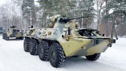 In this photo taken from video released by the Russian Defense Ministry Press Service, military vehicles of Russian peacekeepers are waiting to be transported to Russian military planes at an airfield outside Moscow, before being flown to Kazakhstan Jan. 6, 2022.