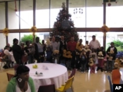 Children pose for a picture with their news toys alongside their parents and volunteers.