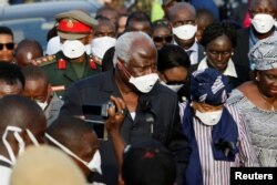 Sierra Leone President Ernest Koroma and Liberian President Ellen Johnson Sirleaf are seen on arrival for the burial of victims of the mudslide, at the Paloko cemetery, in Waterloo, Sierra Leone, Aug. 17, 2017.