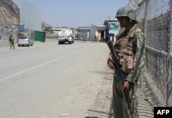 FILE - Pakistani soldiers patrol at the Torkham border crossing between Pakistan and Afghanistan in Pakistan's Khyber Pass on June 14, 2016. Both sides are blaming each other for a recent spike in tensions at the frontier.