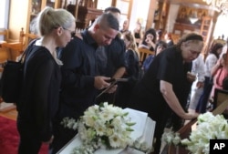 Relatives mourn over the coffins of Livia Florentian Bunea, 36, from Romania and her daughter Elena Natalia, 8, at a church in Arediou, Cyprus, June 13, 2019. The mother and daughter are believed to have been the first victims of a confessed serial killer.