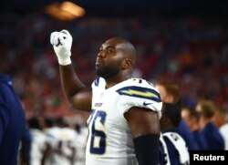 지난 11일 미국 애리조나주 글렌데일 피닉스 스타디움대학에서 애리조나 카디널스와 로스앤젤레스 차저서의 경기에 앞서 미 국가가 흘러나오자 차저스 소속 러셀 오쿵 선수가 주먹 쥔 팔을 높이 올리고 있다. 사진제공=USA TODAY