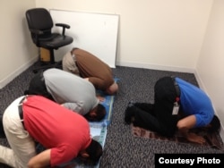 US Muslim Rizwan Jaka (in gray shirt) prays with fellow employees at his workplace. (Photo by Shad Imam)