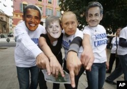Anti-globalization members wearing masks, from left, of US President Barack Obama, German Chancellor Angela Merkel, Vladimir Putin Prime Minister of Russia and French President Nicolas Sarkozy demonstrate in Nice, southeastern France, against G20 summit