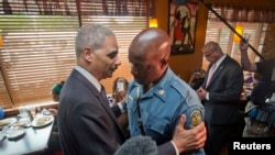 Attorney General Eric Holder greets Capt. Ron Johnson of the Missouri State Highway Patrol at Drake's Place Restaurant in Florrissant, Missouri Aug. 20, 2014.