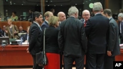 EU foreign ministers talk to each other prior to the start of the EU foreign ministers council at the European Council building in Brussels, Monday, March 17, 2014.