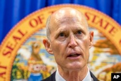 Florida Governor Rick Scott lays out his school safety proposal during a press conference at the Florida Capitol in Tallahassee, Fla., Feb. 23, 2018. Scott proposed banning the sale of firearms to anyone younger than 21 as part of a plan to prevent gun violence.