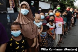 Sejumlah warga antre menerima bantuan dari Presiden Joko Widodo di tengah pandemi virus corona, di Jakarta, Jumat, 16 Juli 2021. (Foto: Willy Kurniawan/Reuters)