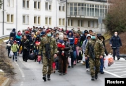 Migrants walk toward the Austrian border town of Spielfeld in the village of Sentilj, Slovenia, Feb. 16, 2016.