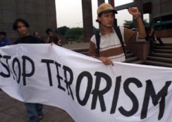 Dua aktivis mahasiswa memegang spanduk saat demonstrasi damai di Jakarta, 22 September 2000. (Foto: AFP/Oka Budhi)