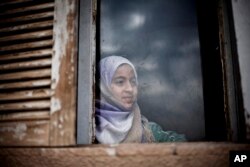 A Syrian girl from Aleppo looks outside a window of an abandoned building where her and several families took refuge due to fighting between Free Syrian Army fighters and government forces in the northeastern city of Qamishli, Syria, Thursday, Feb. 28, 2013. (AP Photo/Manu Brabo)