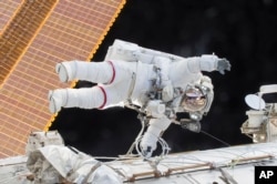 FILE - In this Dec. 21, 2015, photo provided by NASA, Expedition 46 Commander Scott Kelly participates in a spacewalk outside the International Space Station.