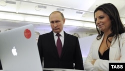 Russia -- Russian President Vladimir Putin and Editor-in-Chief of the RT (Russia Today) Margarita Simonyan at the exhibition to mark the channel's 10th anniversary, Moscow, December 10, 2015.