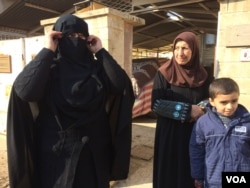 Dalia covers herself with her veil to show journalists what she looked like under IS rule. When authorities were on the streets, she says, she also had her eyes covered with another layer of fabric in Mosul, Iraq, Jan. 23, 2017. (H. Murdock/VOA)