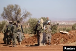FILE - Rebel fighters gather during their advance towards the Islamic State-held city of al-Bab, northern Syria,Oct. 26, 2016.