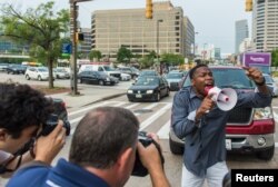 FILE - A demonstrator blocks traffic as protests moved into the street on the first day of pretrial motions for six police officers charged in connection with the death of Freddie Gray in Baltimore, Maryland, Sept. 2, 2015.