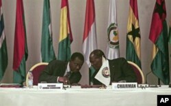 Alassane Ouattara (à dr.) président de la CEDEAO, s'entretient avec l'un des participants au sommet d'Abidjan