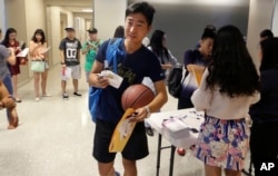 FILE - Weikang Nie, a graduate student in finance from China, walks into an orientation for Chinese students at the University of Texas-Dallas in Richardson, Texas, Aug. 22, 2015.