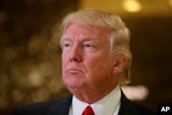 President-elect Donald Trump speaks with reporters in the lobby of Trump Tower in New York, Friday, Jan. 13, 2017.