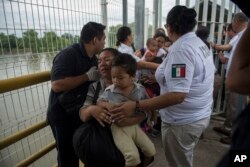 A Honduras migrant mother and her son walk through the bridge after crossing the border between Guatemala and Mexico, in Ciudad Hidalgo, Mexico, Oct. 20, 2018.