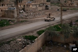 A Humvee drives in a village recently retaken from Islamic State militants by U.S.-backed Syrian Democratic Forces near Baghouz, Syria, Feb. 17, 2019.