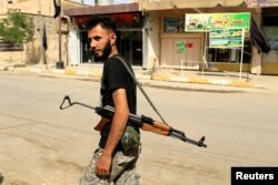 A member of Shi'ite Popular Mobilization Forces (PMF) walks in the street of Turkoman neighborhood Shia in Tuz Khurmato, Iraq, Sept. 24, 2017.