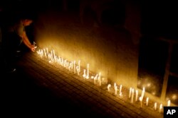 A man places a candle during a vigil at the Polytechnic School in Rosario, Argentina, Nov. 1, 2017, remembering five alumni killed Tuesday in New York. (AP photo)