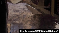 Sacks of grain are pushed from a World Food Programme plane over Ganyiel in Unity state, South Sudan, on March 18, 2014.